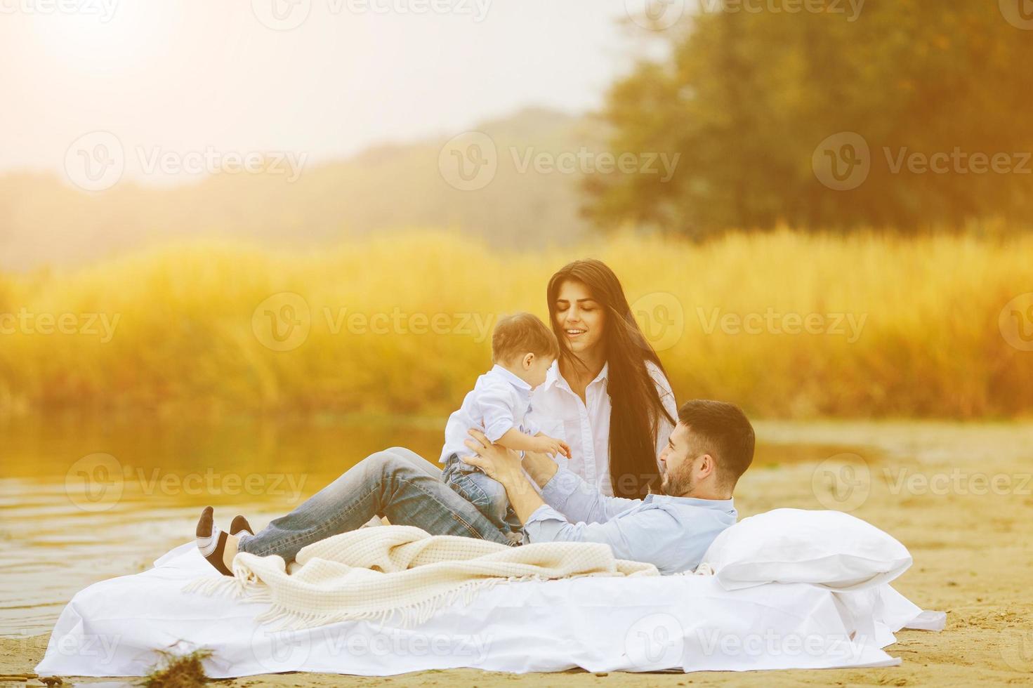 Happy young family relaxing together on the lake photo