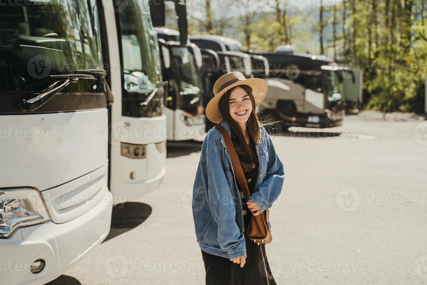 Girl wearing a hat and a vintage style dress is standing on a parking. photo