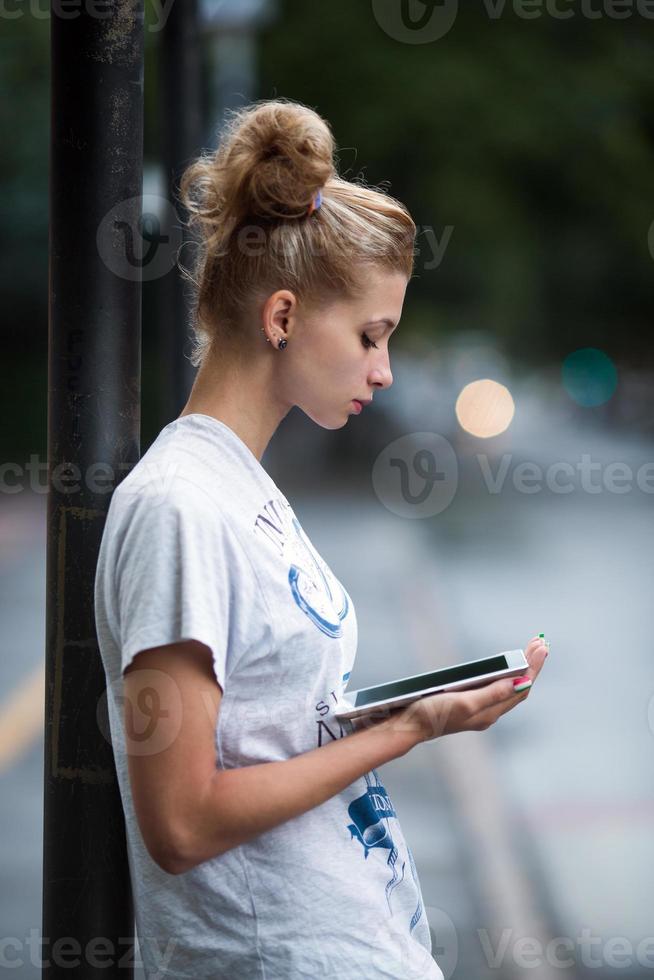 lindas chicas con tableta en una estación de autobuses foto