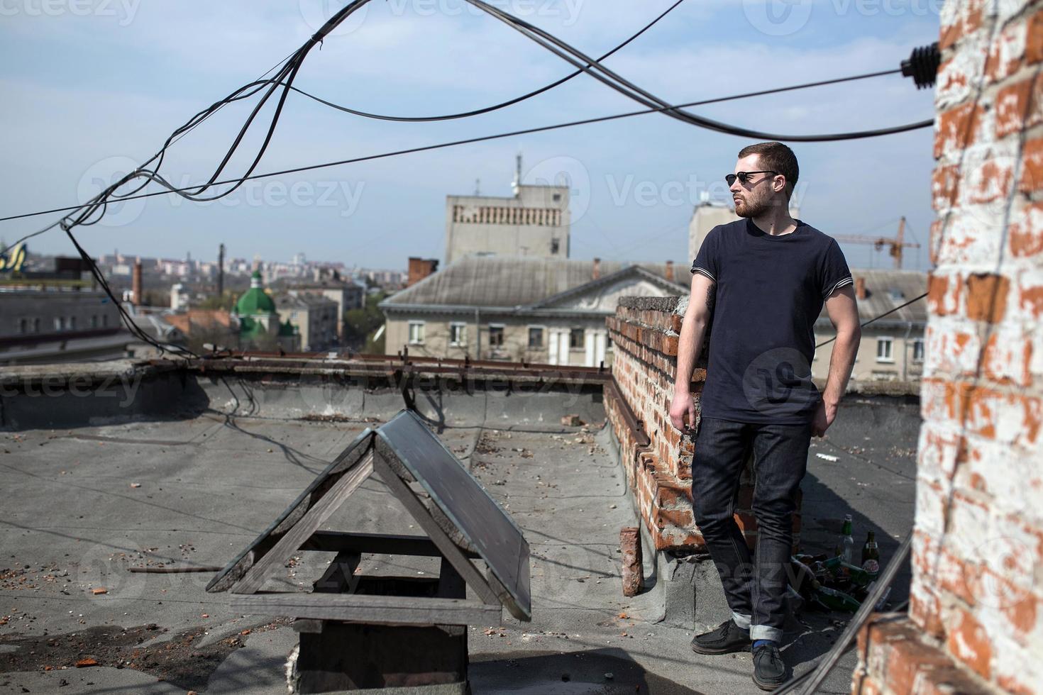 The man in the authentic boots and jeans selvedge on the roof of the building in the old town photo