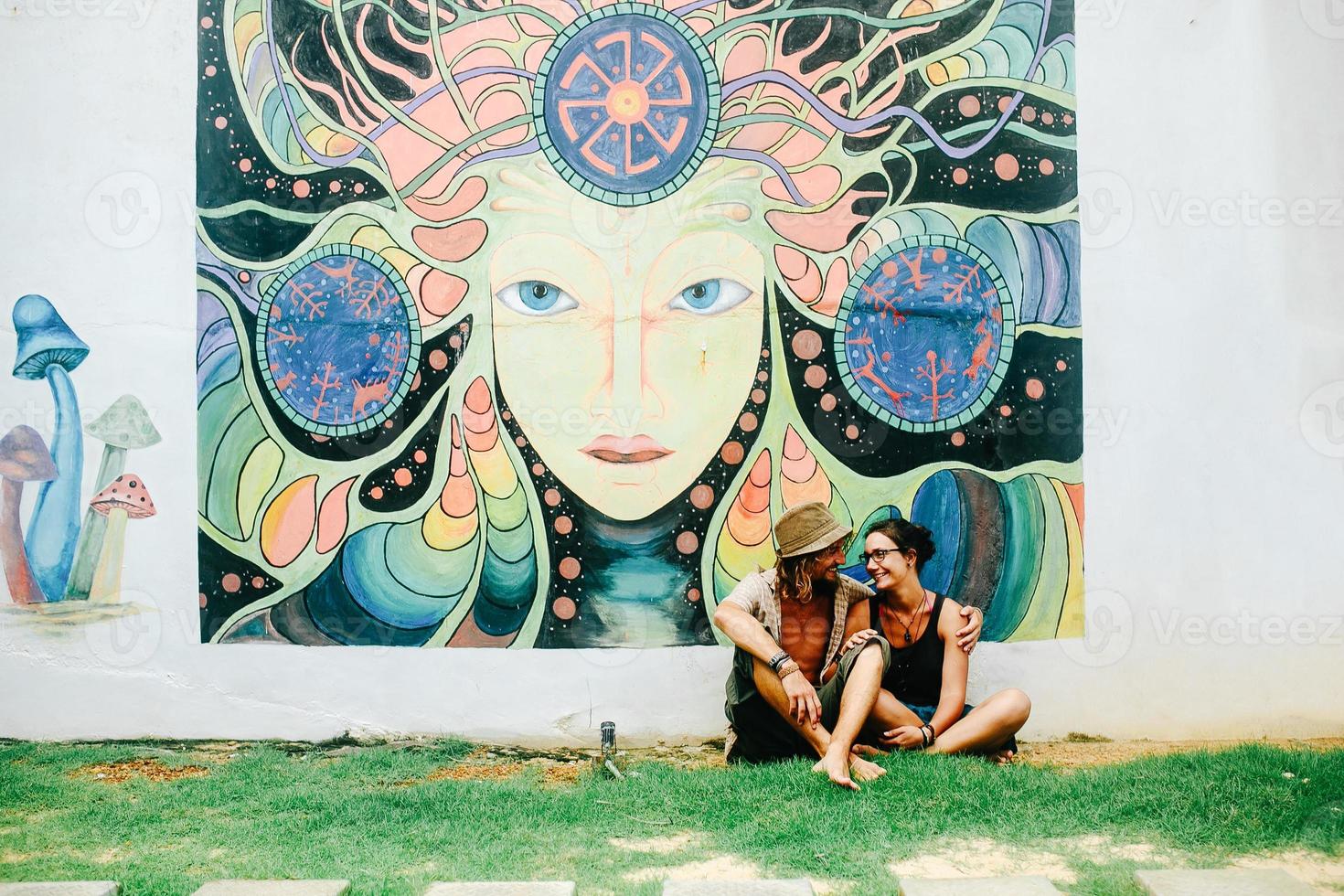 guy and the girl are sitting on the grass photo