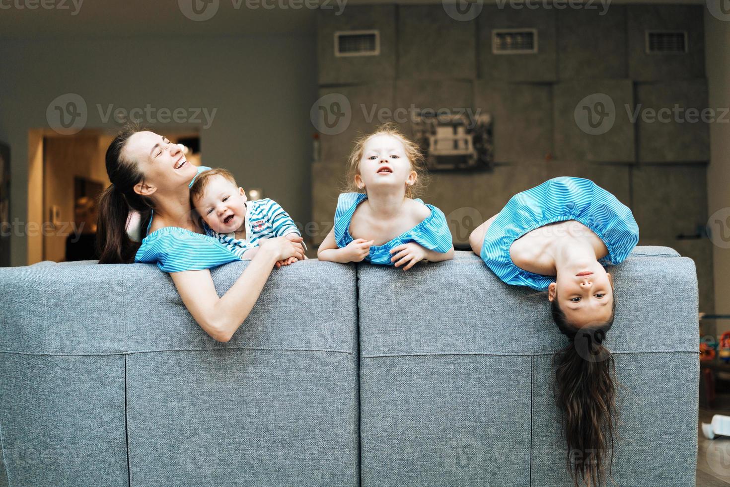 mamá, dos hijas y un hijo pequeño en el sofá foto