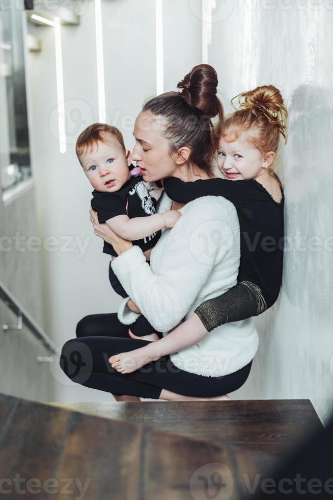 Mom and son in her arms, daughter on her back photo