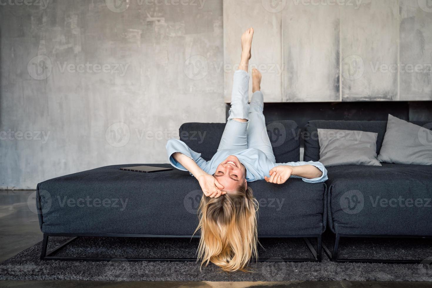 Woman enjoying on a couch with head upside down. photo