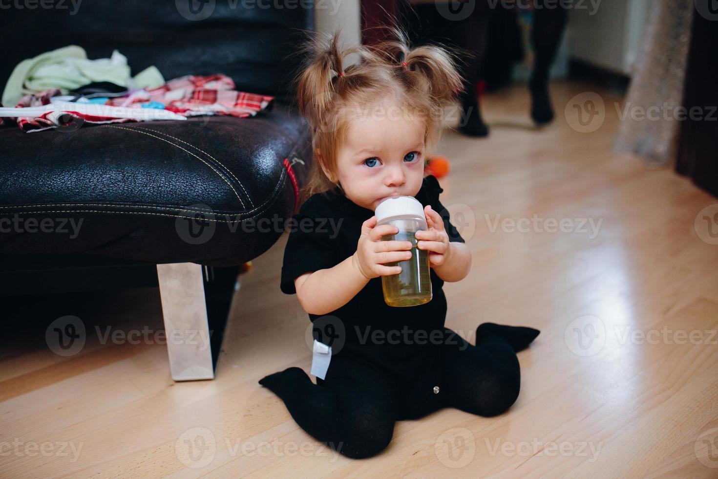 Sweet baby girl sitting on the floor photo