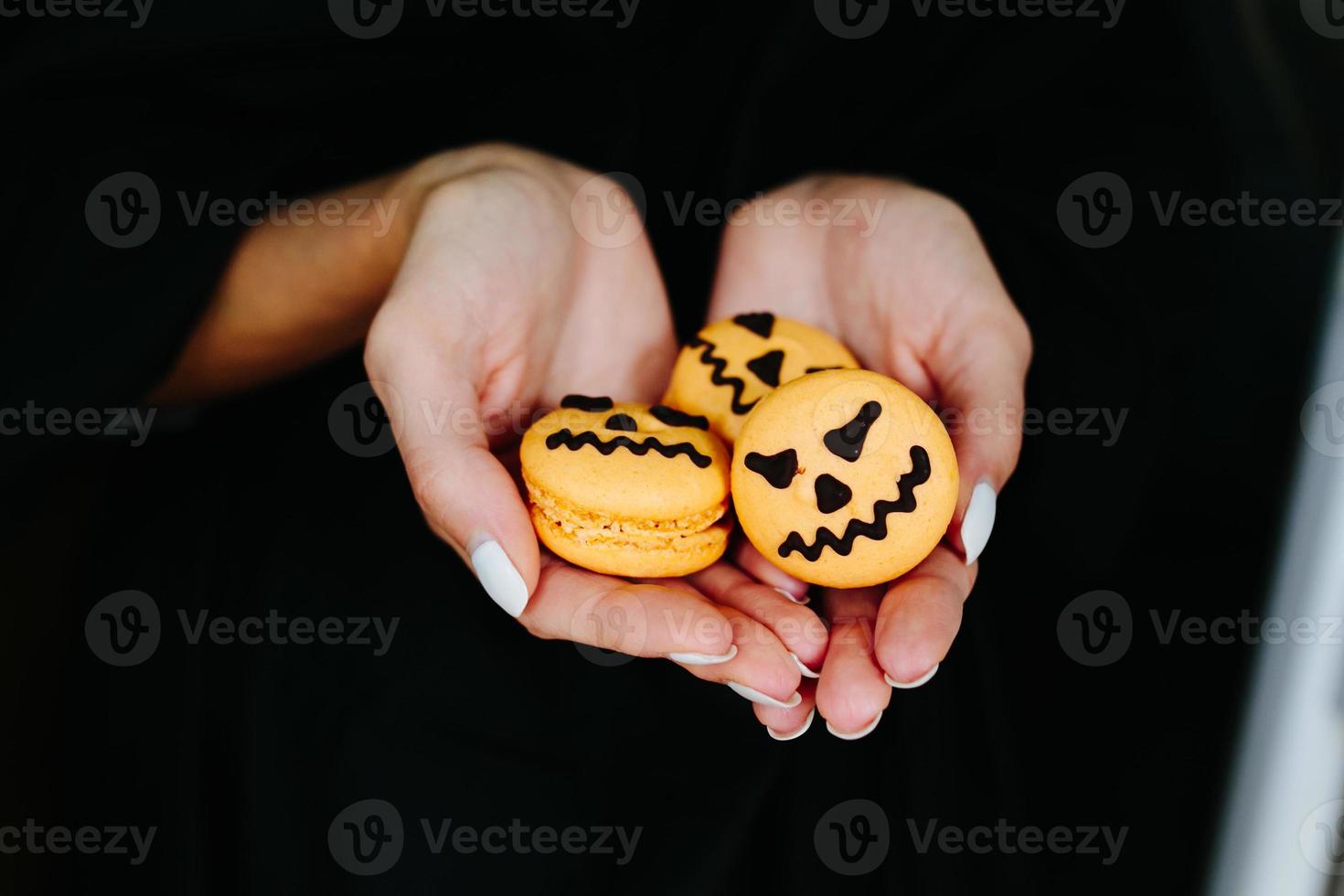 mujer sosteniendo una galleta para halloween foto