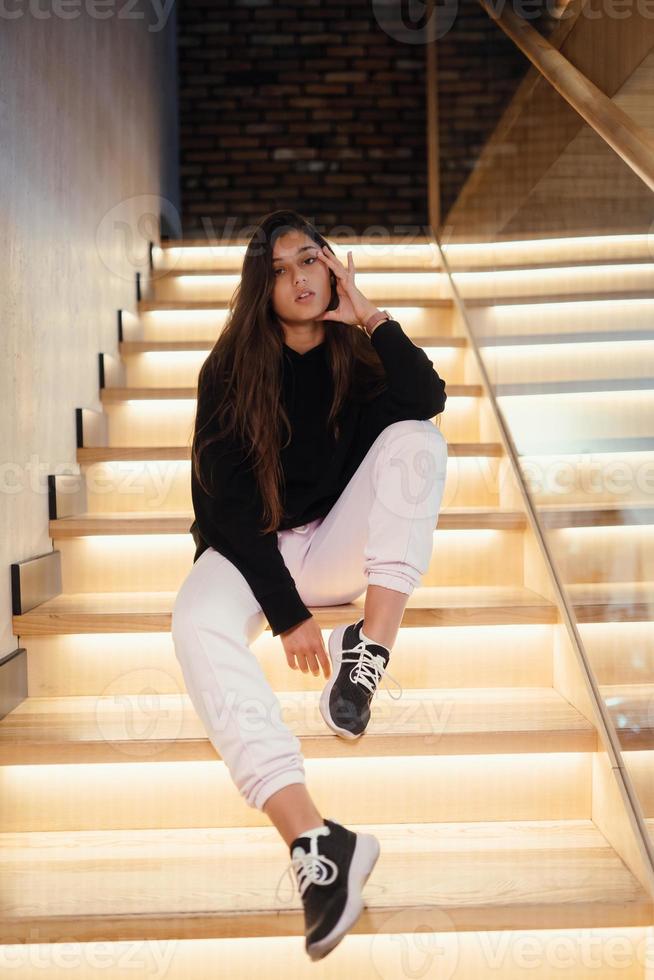 Young beautiful brunette fashion model posing on stairs. photo