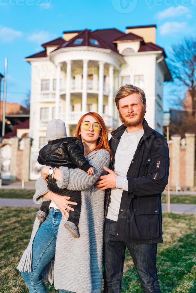 feliz mamá papá e hijo abrazándose en el parque foto