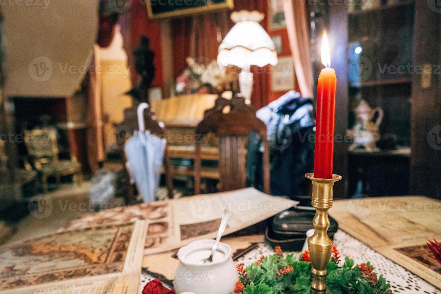 Candlesticks with red candle on the table photo