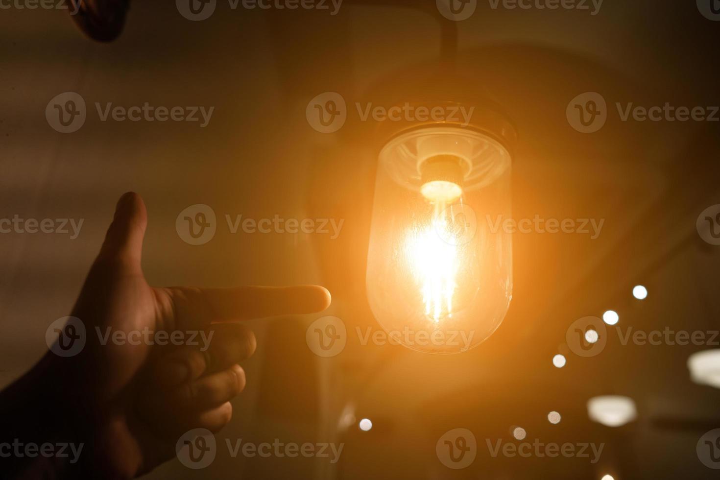 Hand reaching for a vintage light bulb. photo