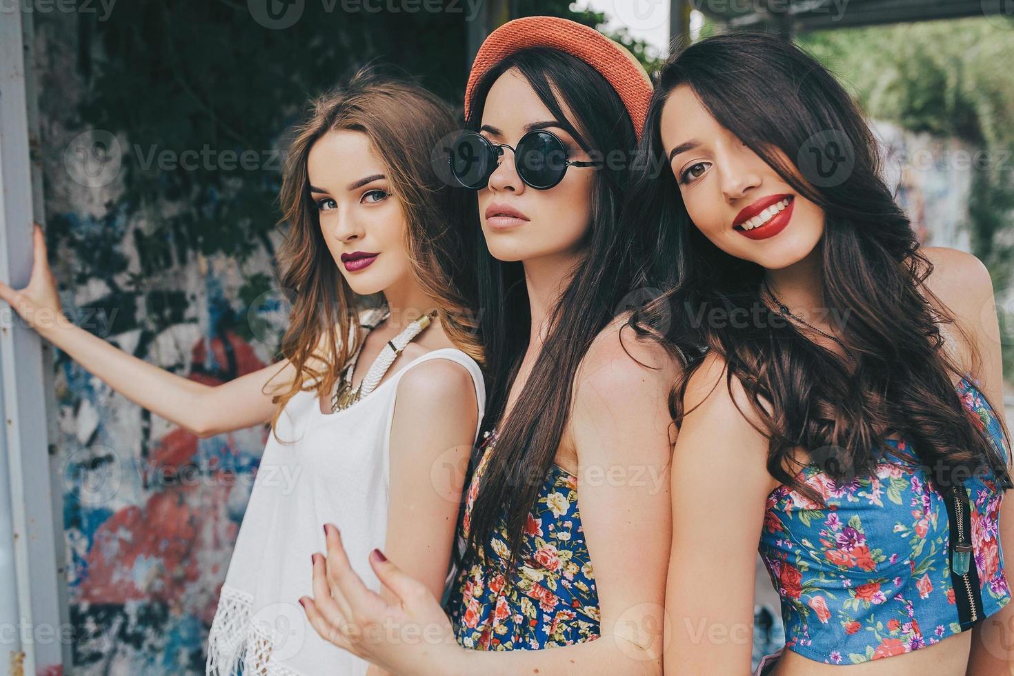 Three beautiful young girls at the bus stop photo