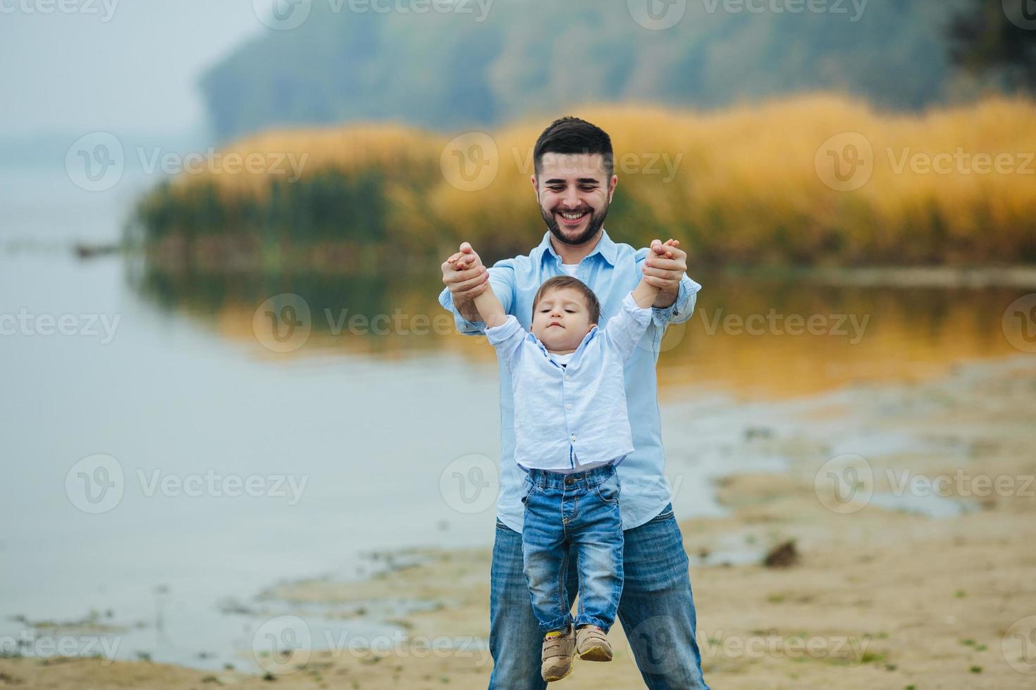 Dad holding infant son's hands photo