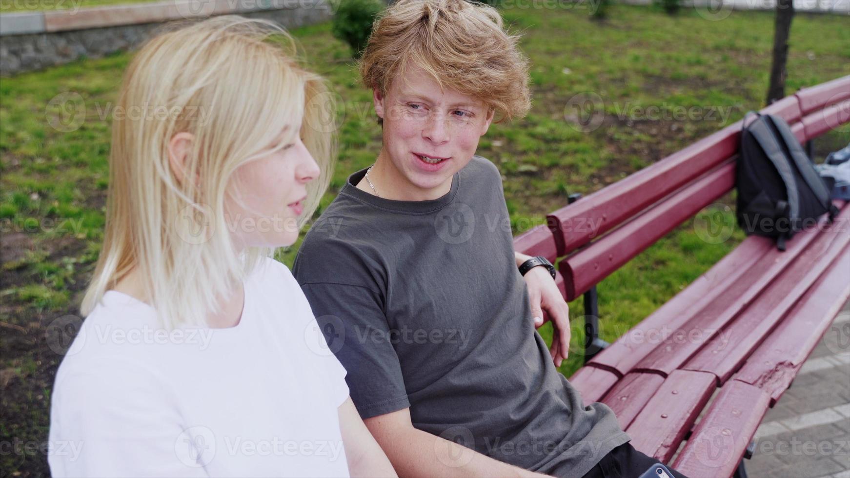 Girl relaxing with her boyfriend seated on a bench photo