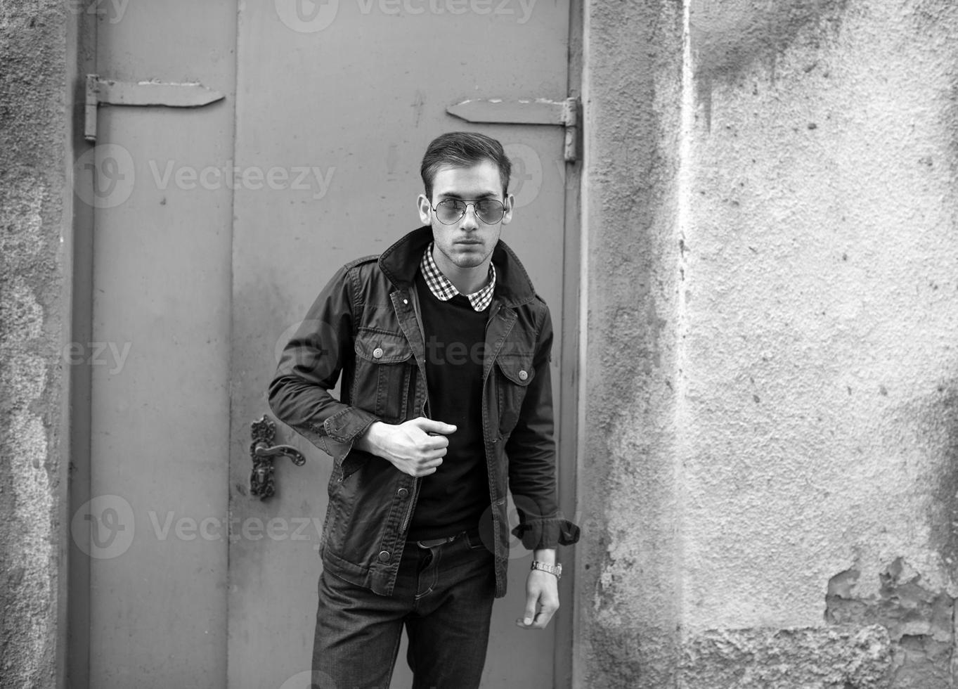 A man dressed in jeans on the background of doors photo