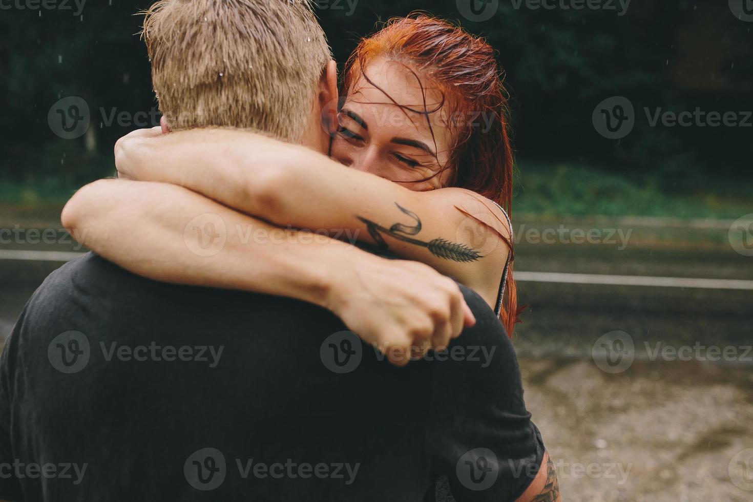 beautiful couple hugging in the rain photo