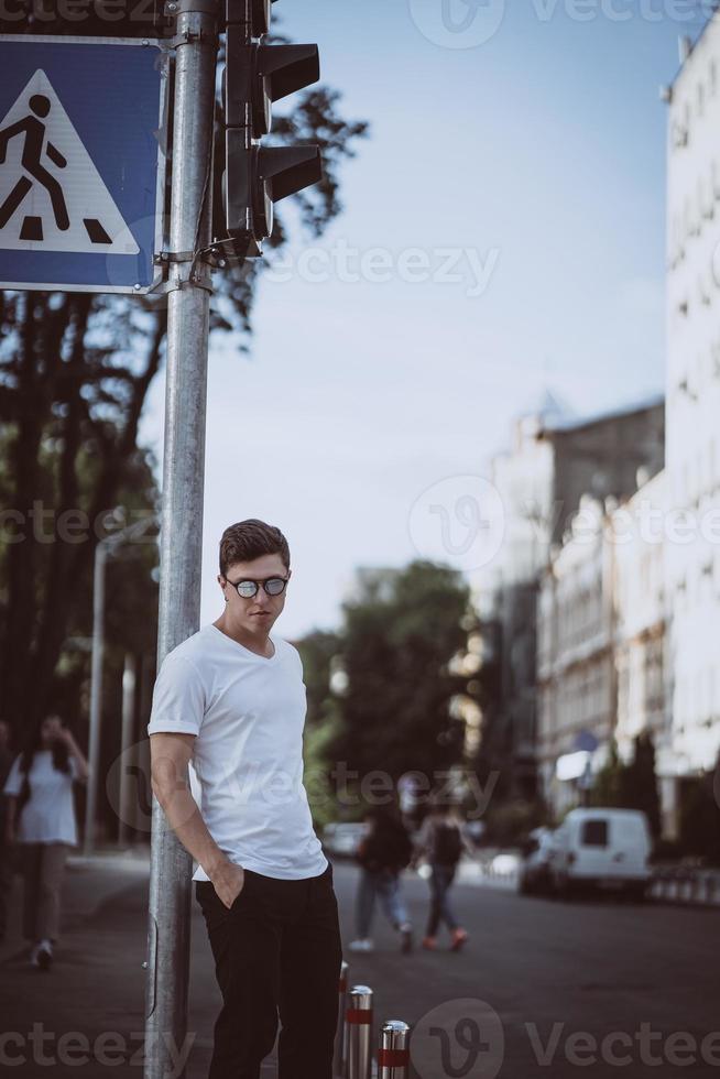 Guy stand on the city street, look camera and around photo