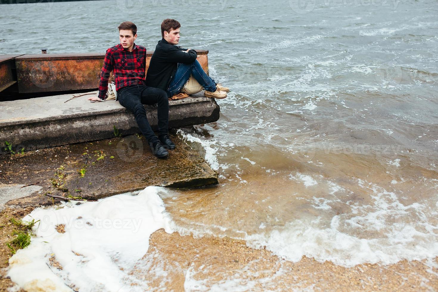 Two friends relaxing on the pier. photo