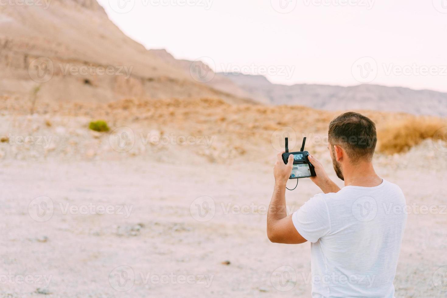 Guy controls drone with remote control photo