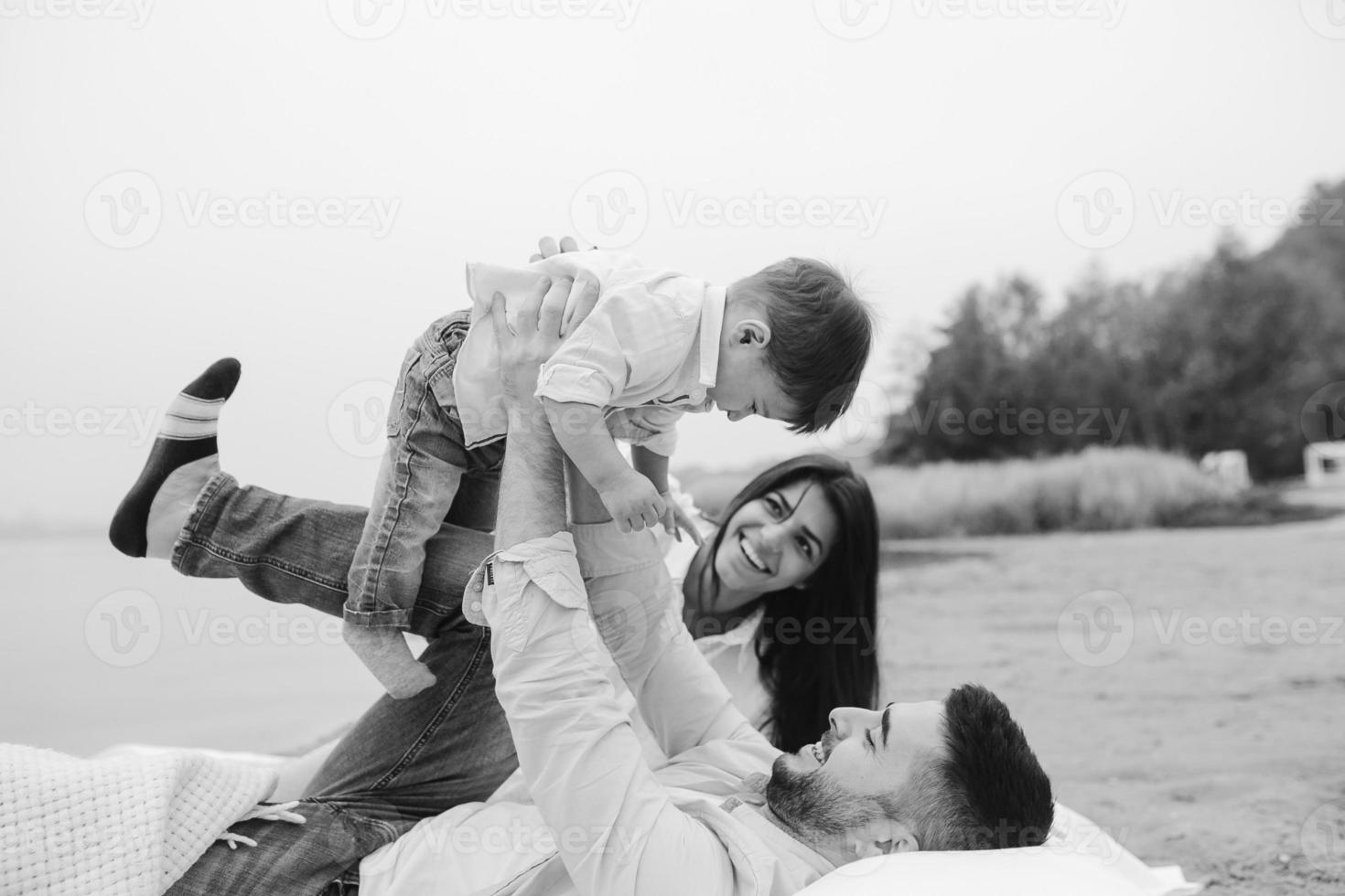 Happy young family relaxing together on the lake photo