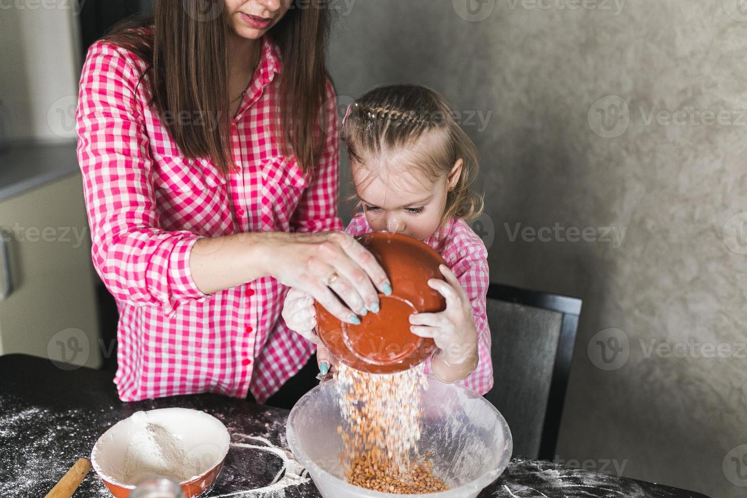 mamá e hija juntas en la cocina foto