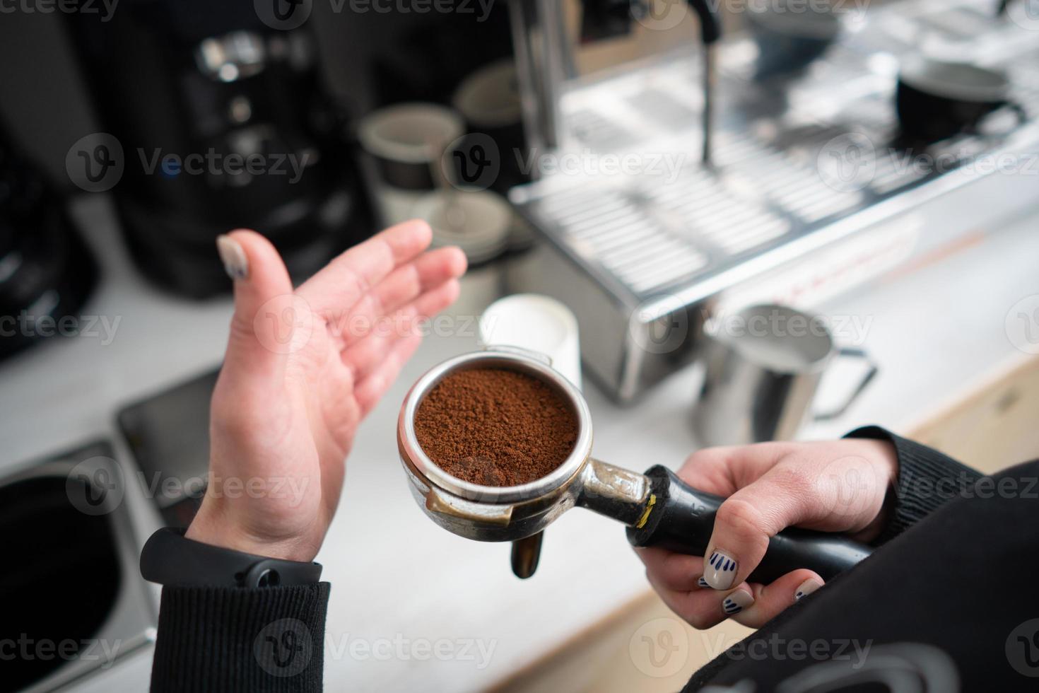 Barista holding portafilter with ground coffee photo
