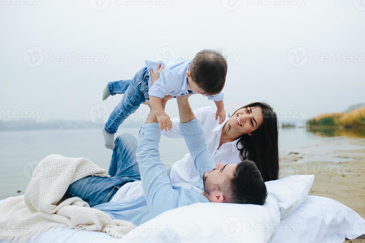 Happy young family relaxing together on the lake photo