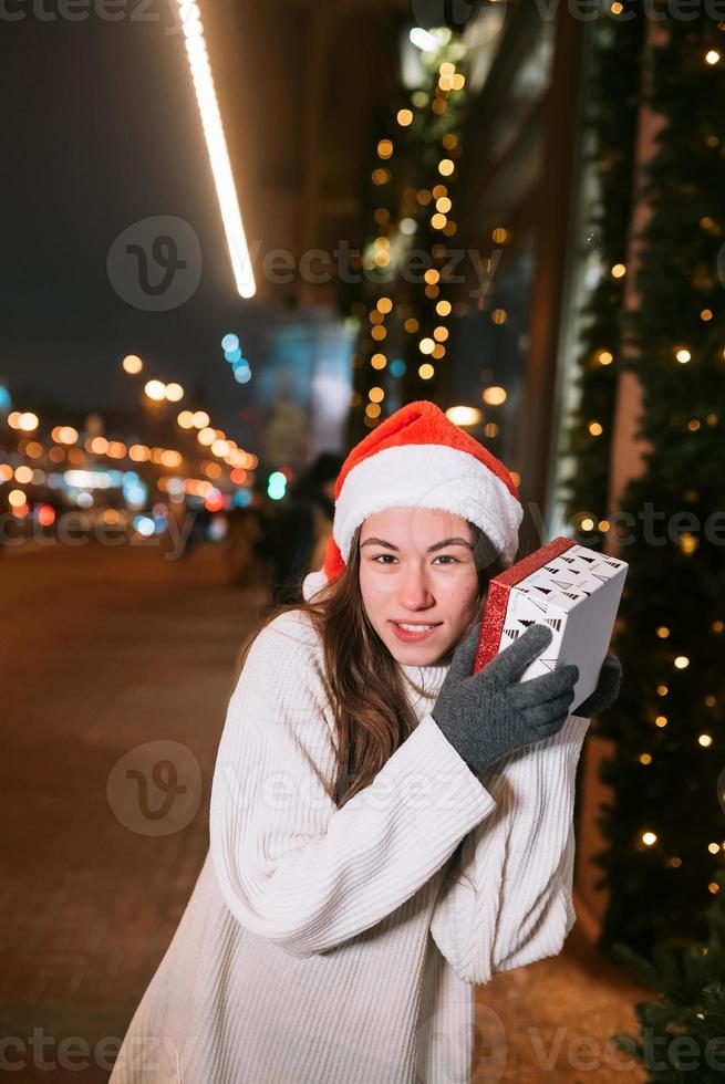 Night street portrait of young beautiful woman acting thrilled. photo