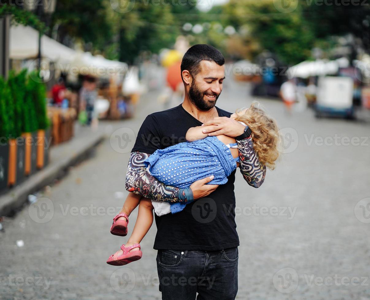 Cute little girl's sleeping in her father's arm photo