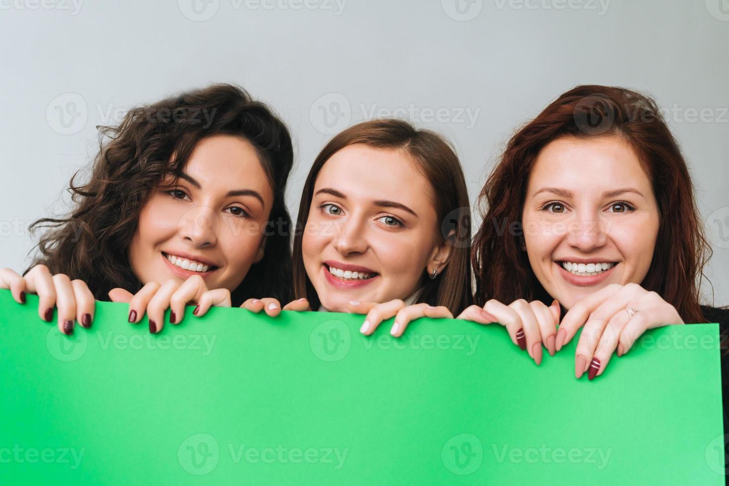Three beautiful young girls posing for the camera photo