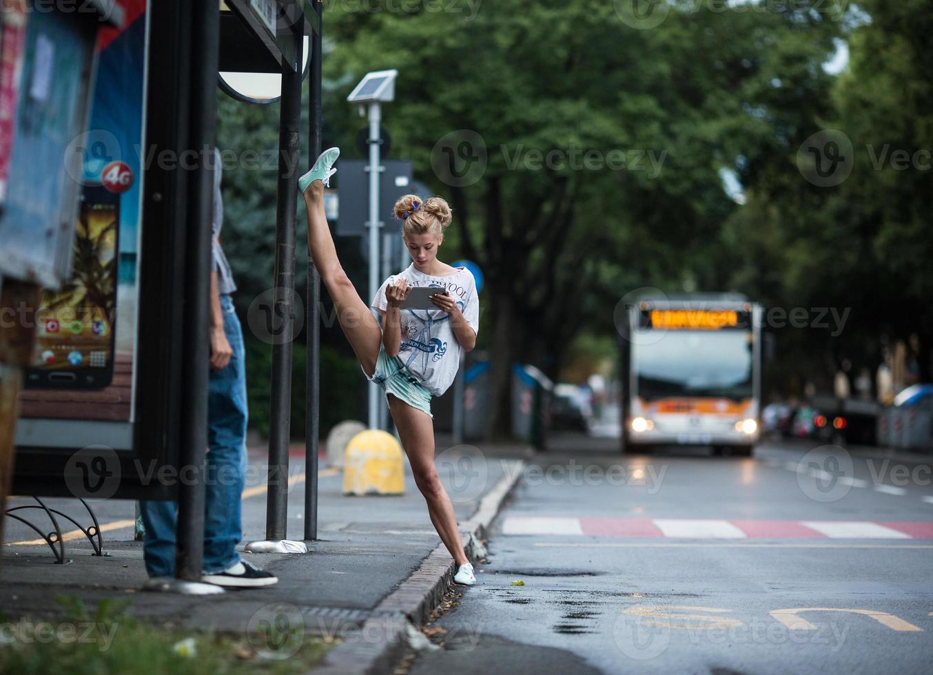 Cute girls with tablet on a bus station with a leg split photo