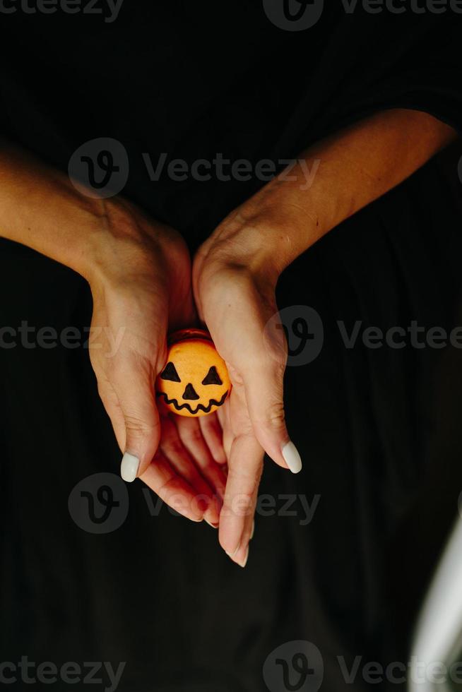 mujer sosteniendo una galleta para halloween foto