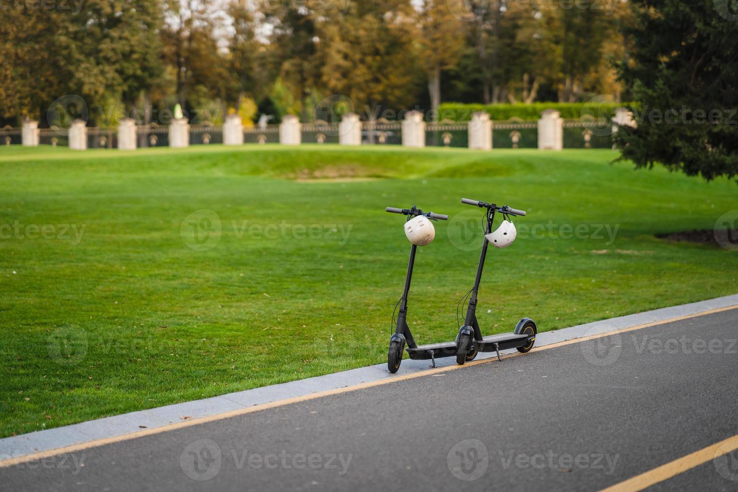 dos scooters eléctricos o e-scooter estacionados al margen de la carretera foto