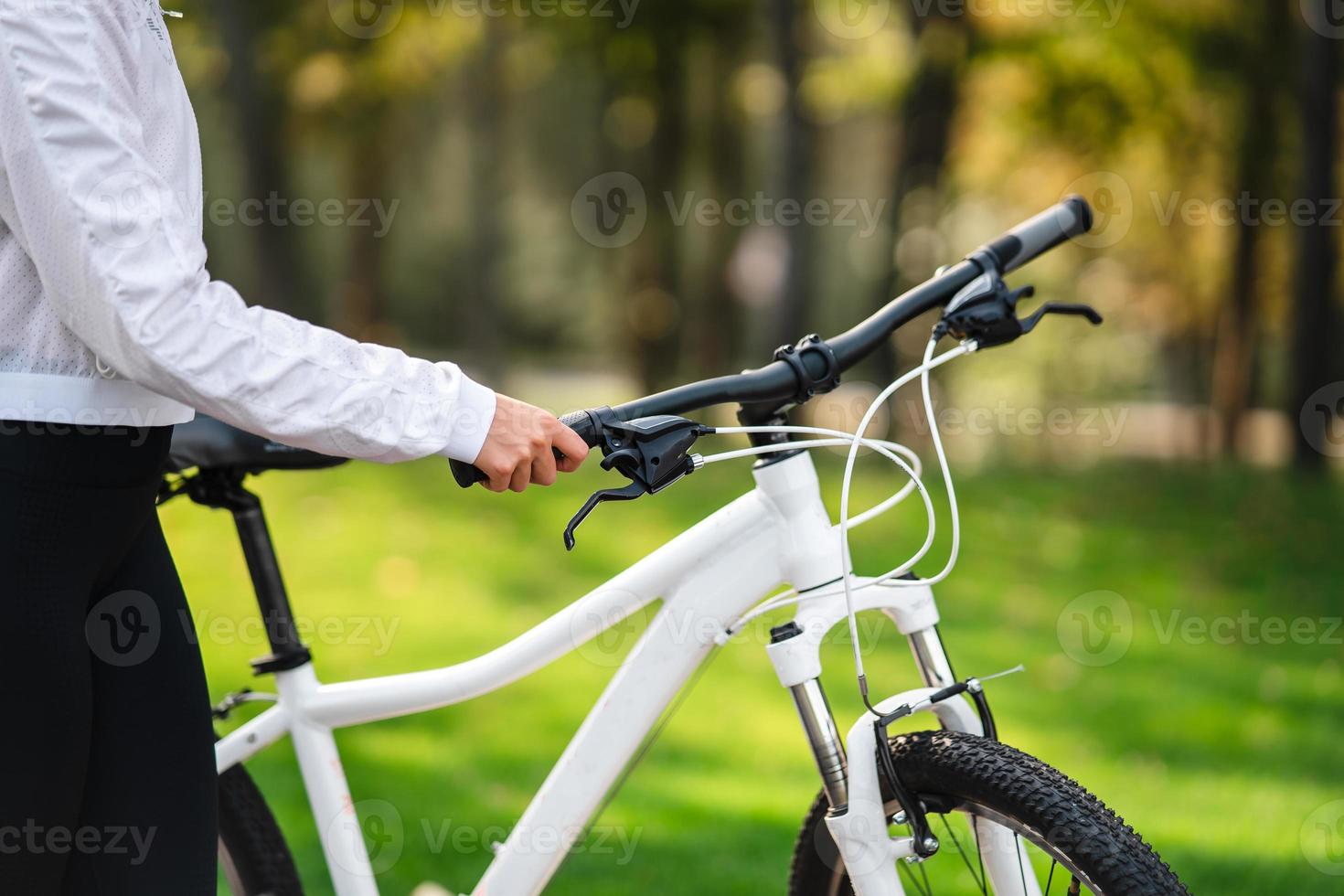 Beautiful girl posing at white bicycle. Walk in nature. photo