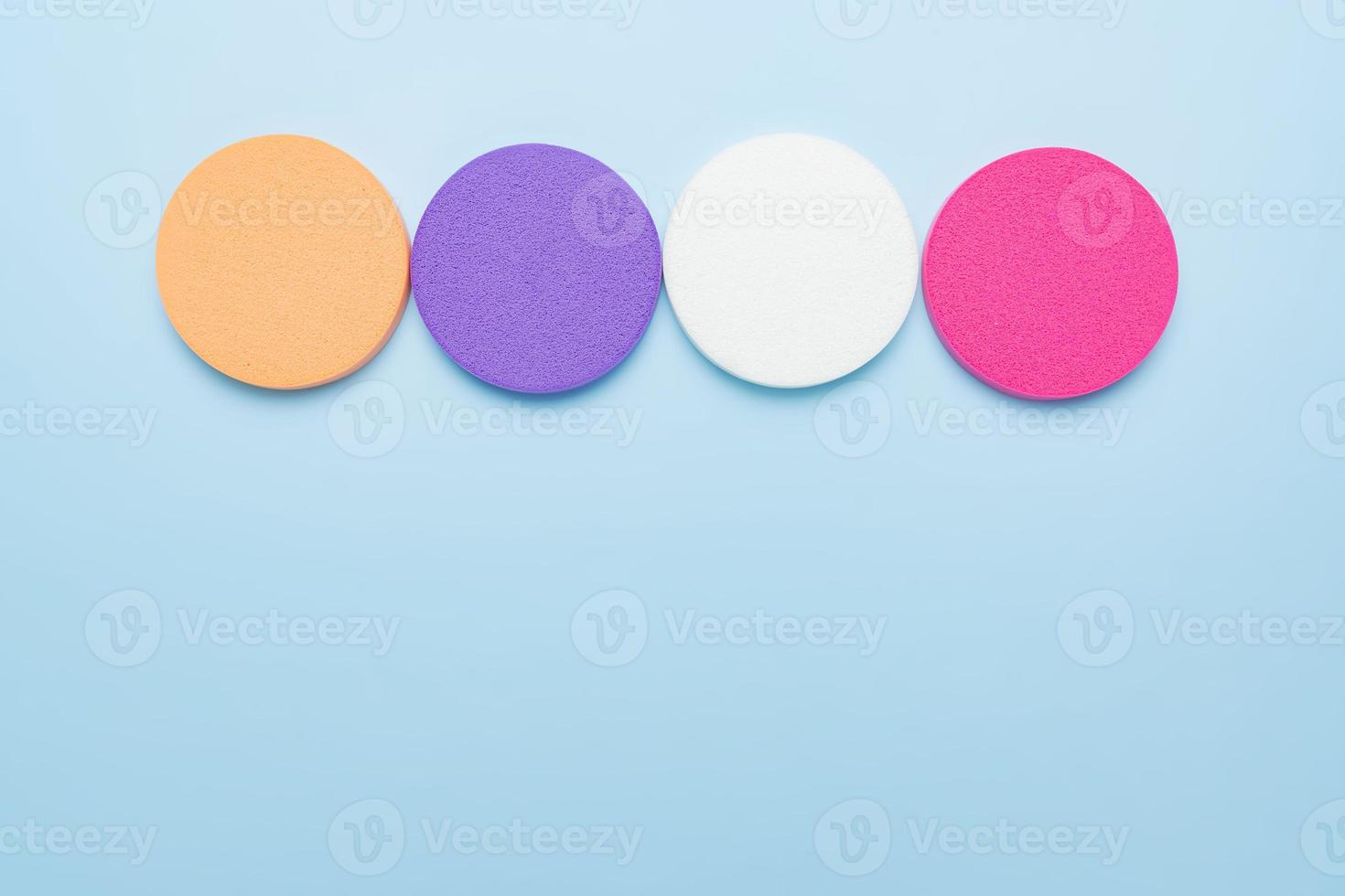 Makeup trendy background with copy space. Set of multicolored round cosmetic sponges for liquid foundation or compact powder. Face skin visage, accessory for makeup photo