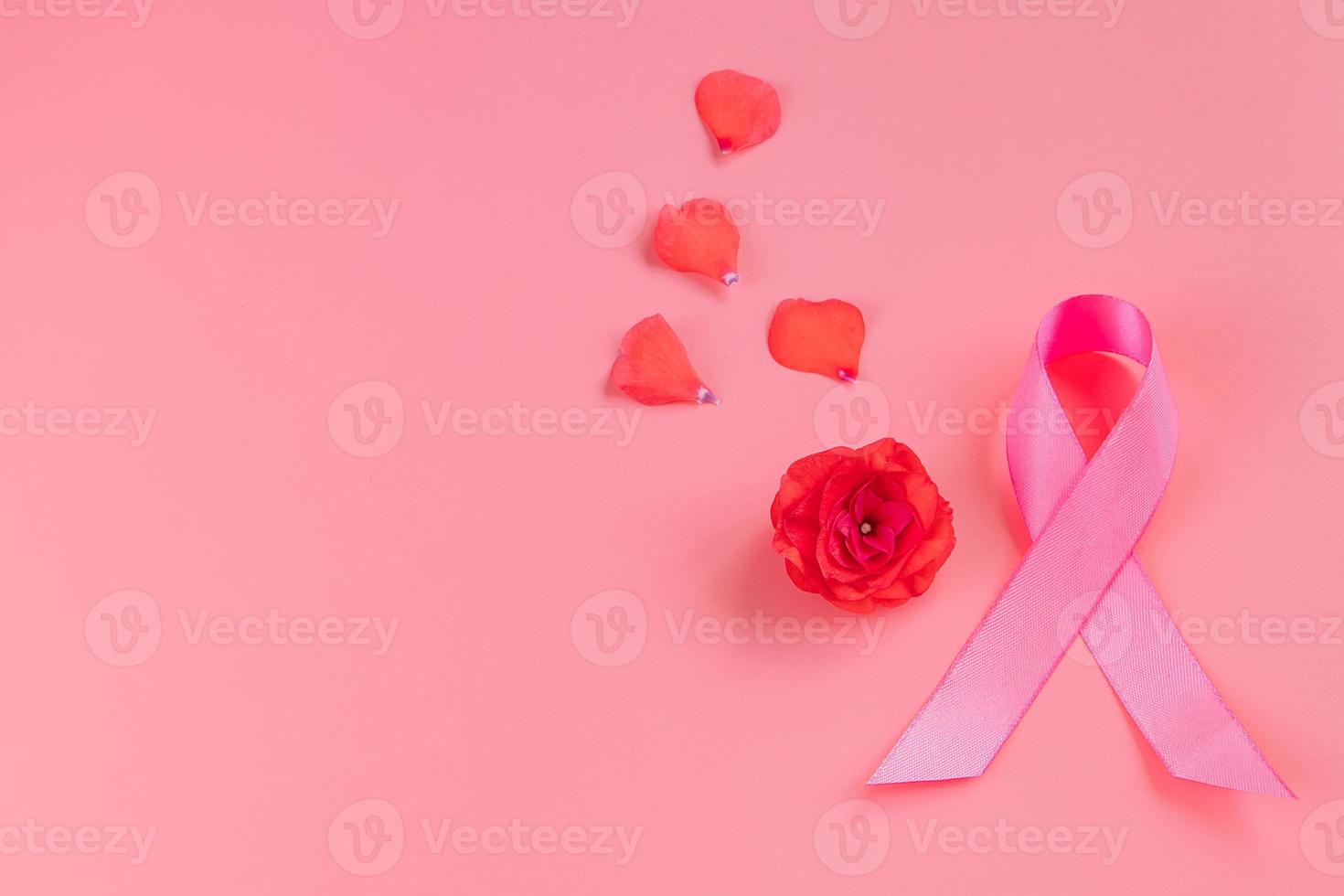 mes de la conciencia del cáncer de mama. cinta rosa y flor sobre fondo de color. concepto de atención de la salud de la mujer. símbolo de esperanza y apoyo. foto