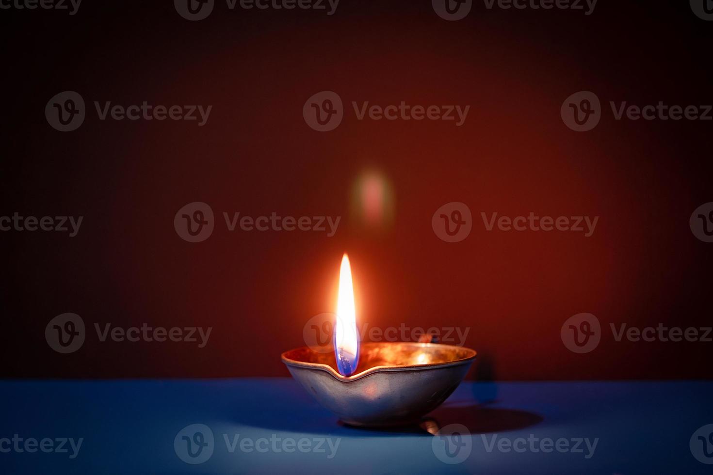 Happy Diwali. Traditional symbols of Indian festival of light. Burning diya oil lamps and flowers on red background. photo