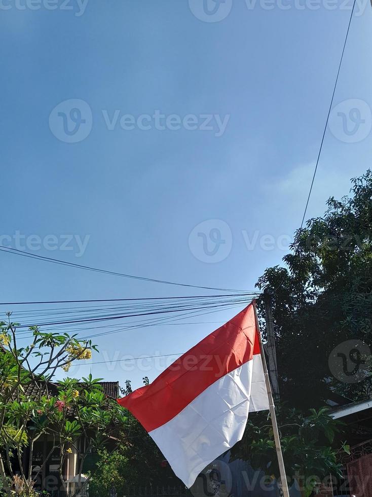 la bandera indonesia es roja y blanca con un fondo de cielo azul brillante foto