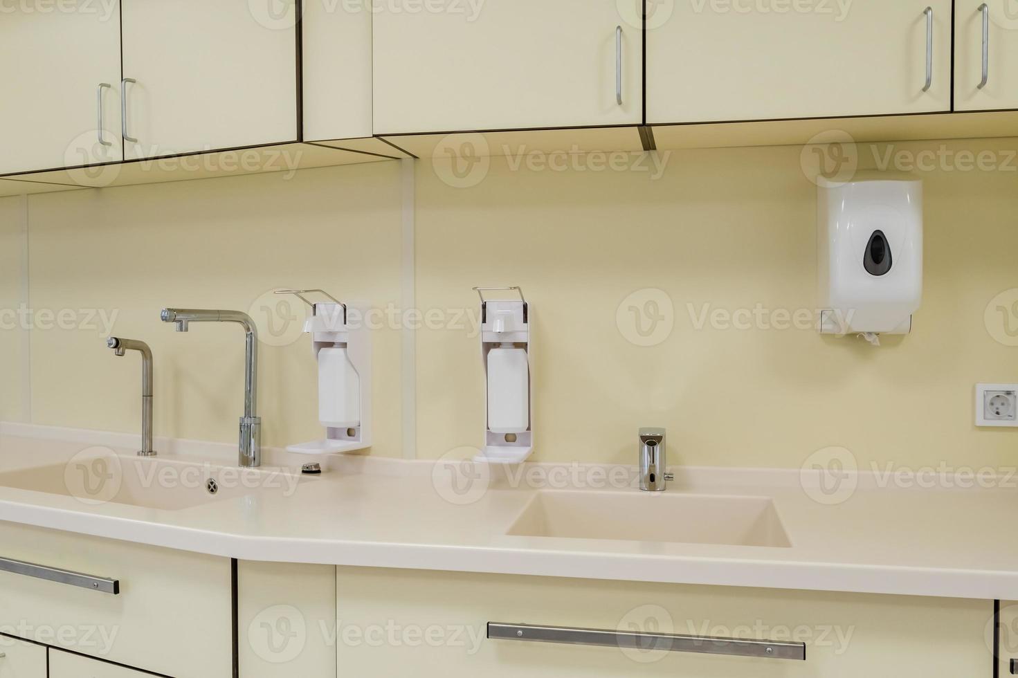 elbow soap and antiseptic dispenser or sanitizer wall mounted for hand disinfection and water tap sink with faucet bathroom or clinic photo