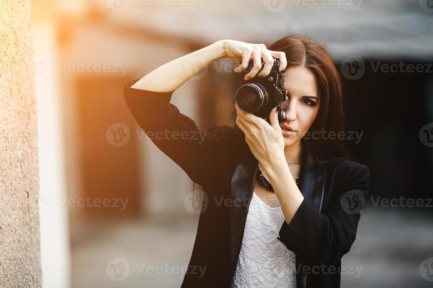 Beautiful female photographer posing with camera photo