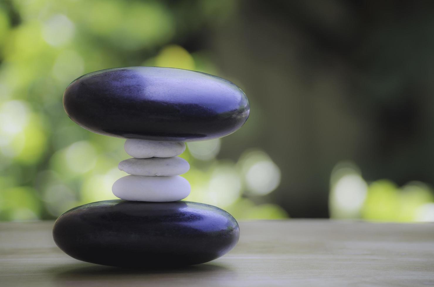 spa pila de piedra blanca y negra sobre mesa de madera, concepto de equilibrio y armonía. foto