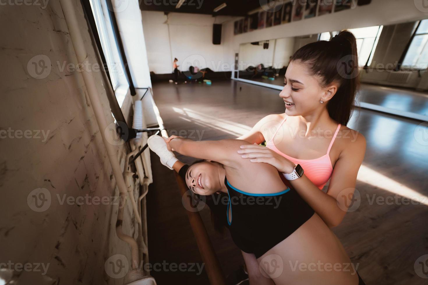 Active sportive woman stretching, young woman helping her photo