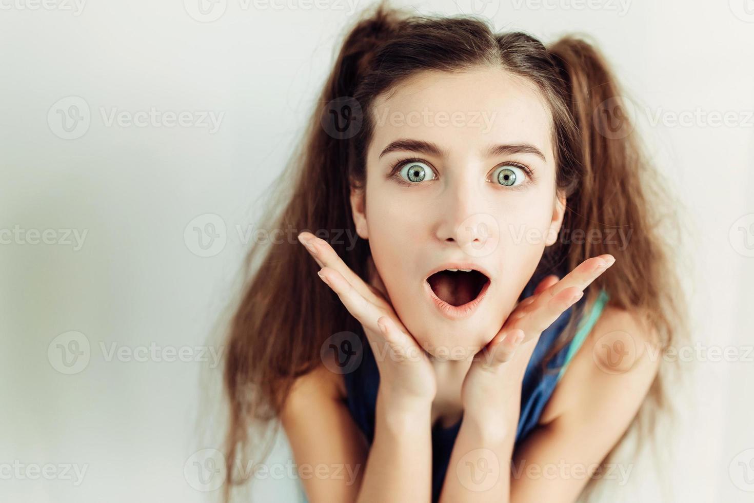 Surprised young girl with pigtails photo