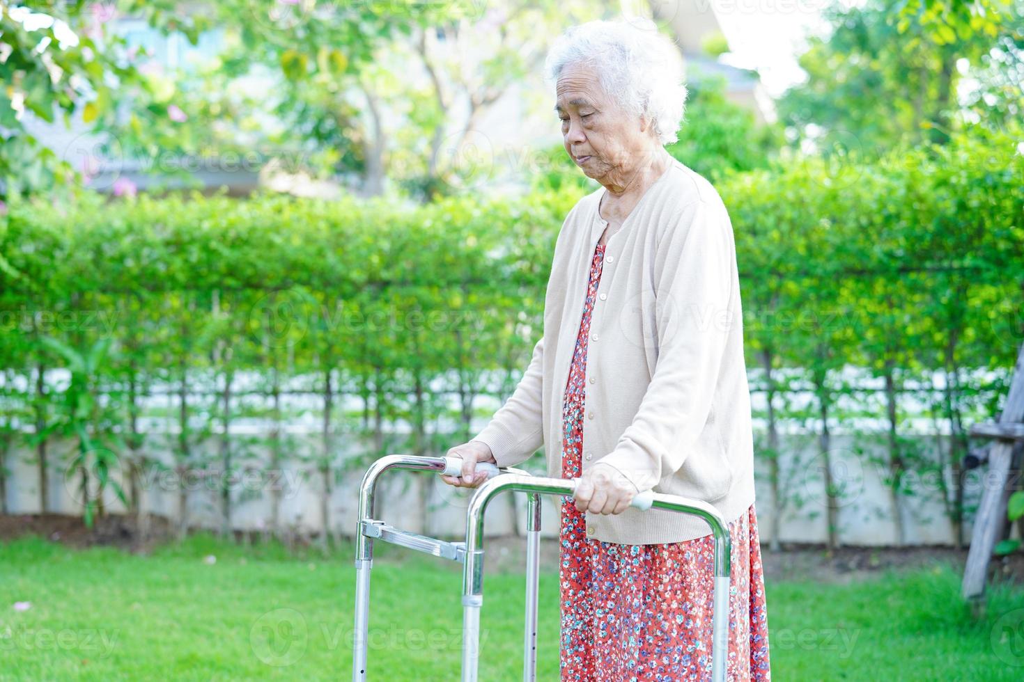 anciana asiática discapacidad paciente caminar con andador en el parque, concepto médico. foto
