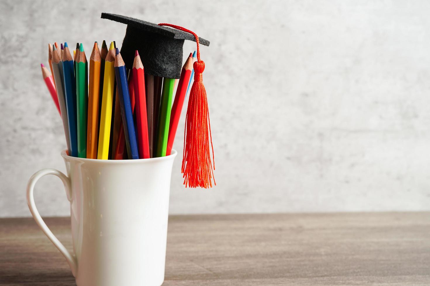 Graduation hat with colorful pencils on book with copy space, learning university education concept. photo