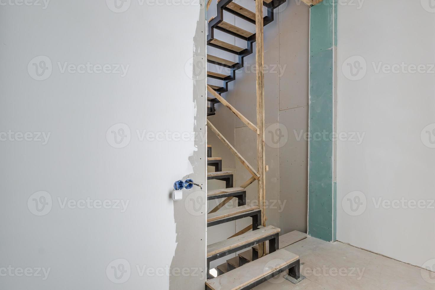 habitación blanca vacía sin reparación y muebles con andamios con escaleras de madera foto