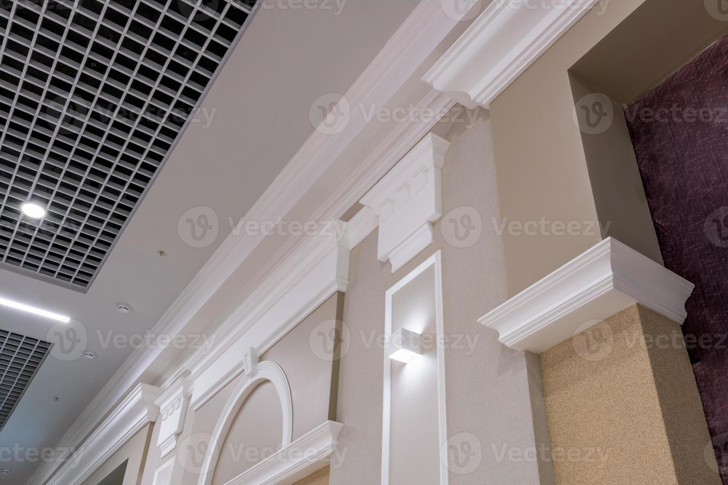 Detail of corner ceiling with intricate crown molding on column with spot light photo