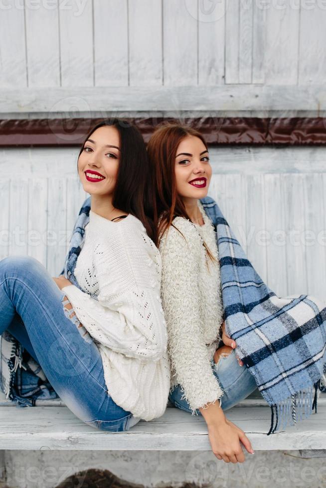 Two girls sit on a bench in the park photo