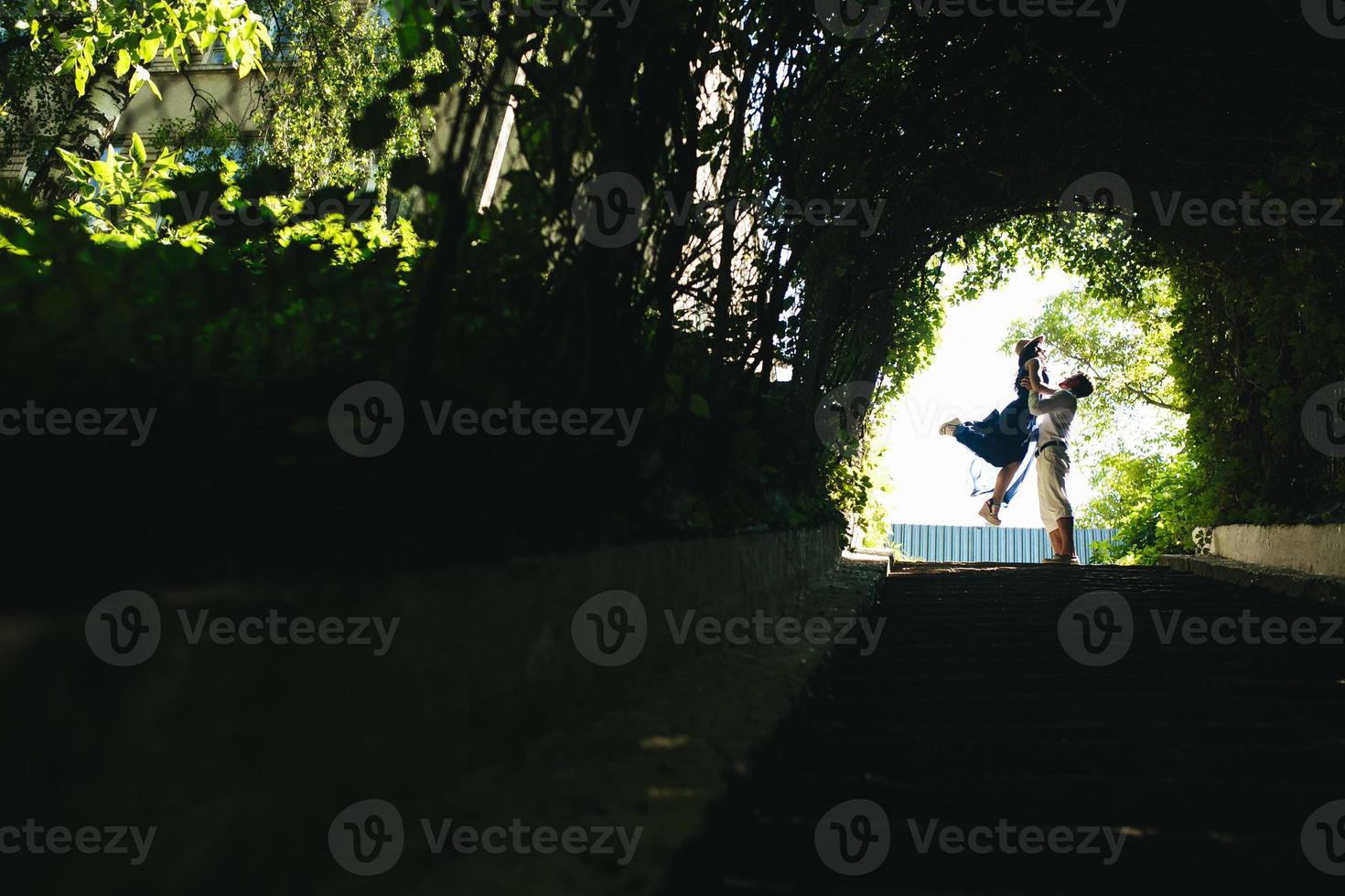 pareja saltando al final del túnel con árboles foto