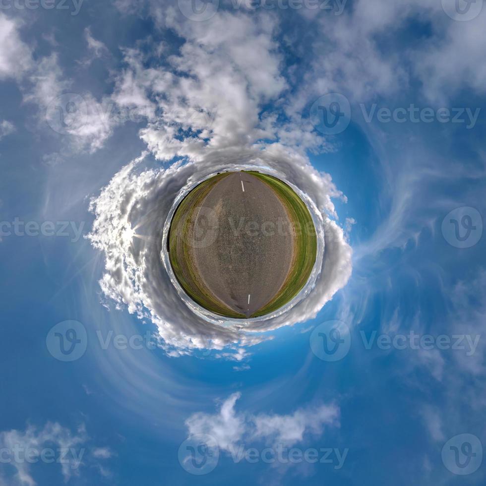 tiny planet in blue sky with beautiful clouds. Transformation of spherical panorama 360 degrees. Spherical abstract aerial view. Curvature of space. photo