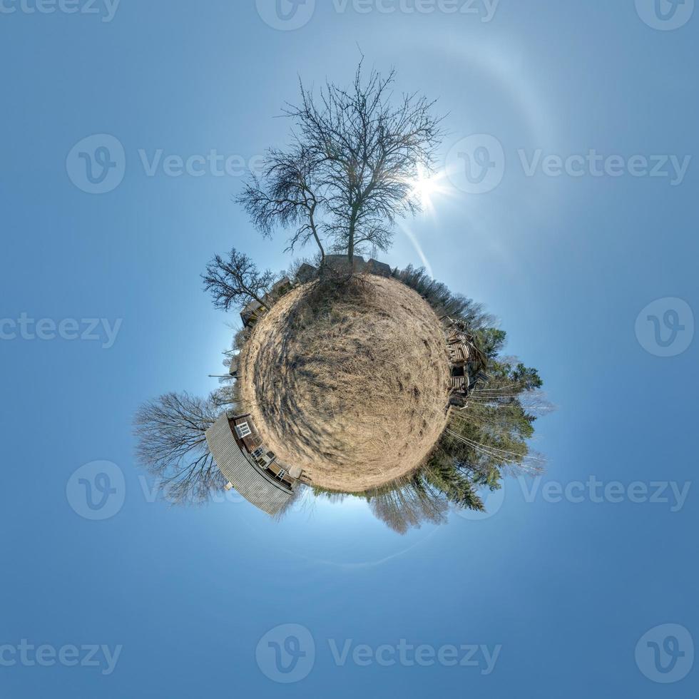 tiny planet in abandoned village near old house in blue sky with beautiful clouds. Transformation of spherical panorama 360 degrees. Spherical abstract aerial view. Curvature of space. photo